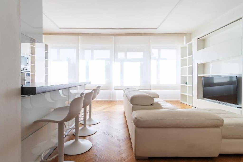 uma sala de estar com um sofá branco e cadeiras em Bilocale vista sul Duomo di Milano em Milão