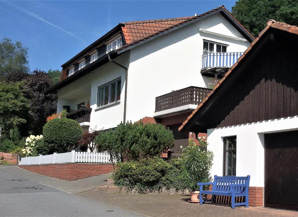 a white house with a blue bench in front of it at Ferienwohnung Haus Sommerberg in Leonhardshof