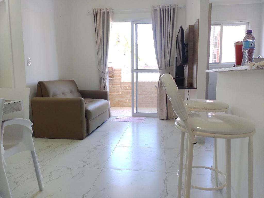 Apartamento a 100 metros da Praia في بيرتيوغا: غرفة معيشة مع أريكة وطاولة وكراسي