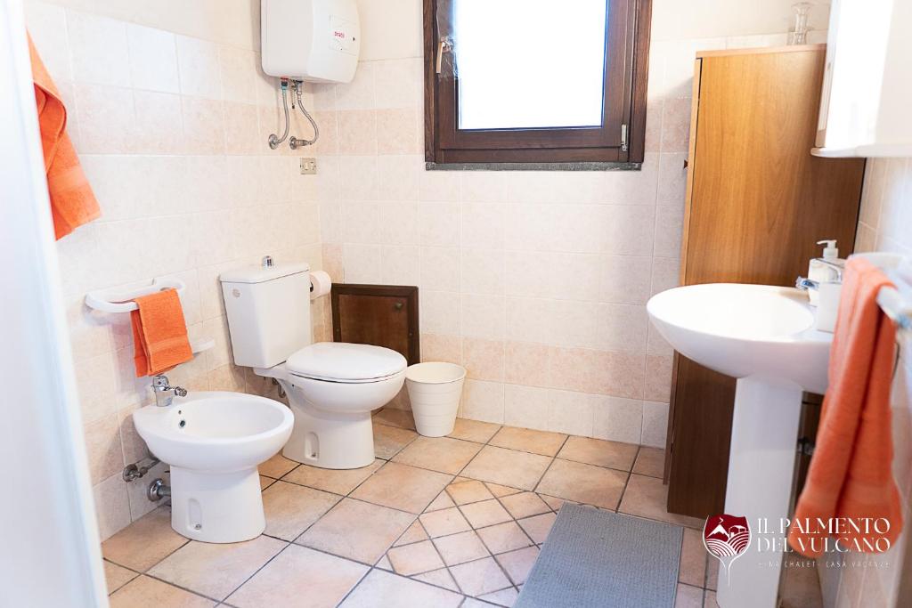ein Badezimmer mit 2 WCs und einem Waschbecken in der Unterkunft Chalet il Palmento del Vulcano in Bronte