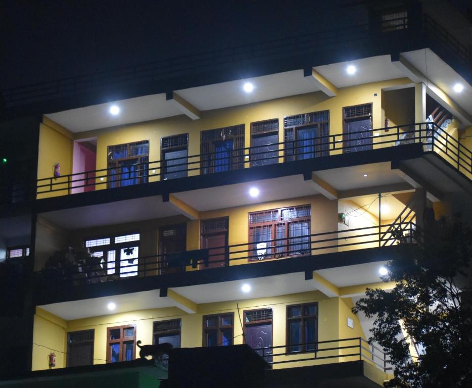 un immeuble avec balcon la nuit dans l'établissement B2 Guest House, à Almora