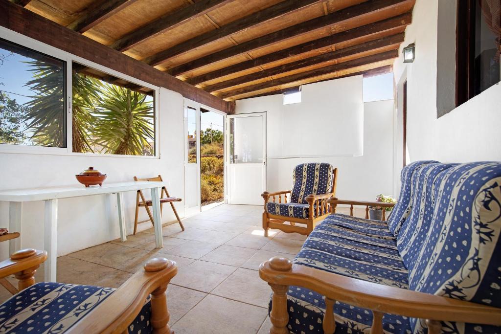 een kamer met stoelen, een tafel en een raam bij Casa Los Guaydiles 2 in Triquivijate