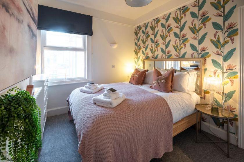 una camera da letto con un grande letto con asciugamani di No33 Number 5 BOUTIQUE COTTAGE a Hunstanton