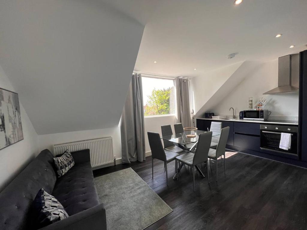 a living room with a couch and a table with chairs at Star London Finchley Road 3-Bed Haven in London