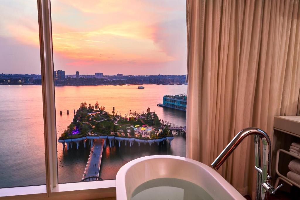 a bathroom window with a view of the water at The Standard, High Line New York in New York