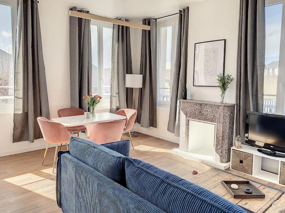 een woonkamer met een blauwe bank en een tafel bij Le Maurice 4 - Villa Maurice in Compiègne