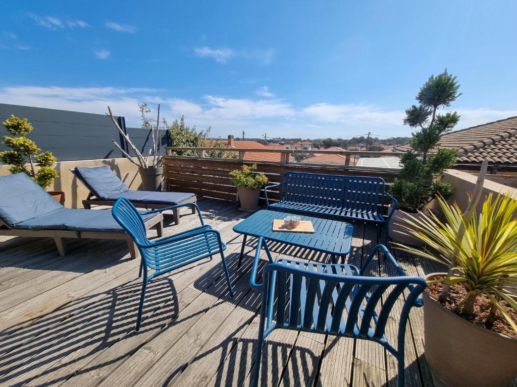 d'une terrasse avec des chaises et des tables bleues. dans l'établissement La Cabane au Sud ~300 m de l'Océan, à Mimizan