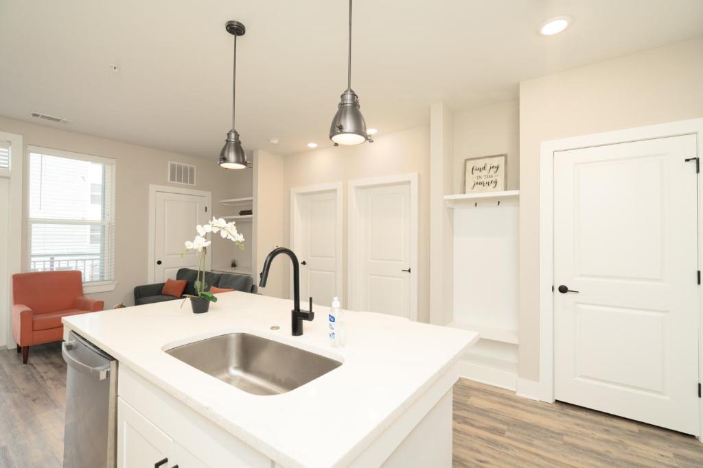 a white kitchen with a sink and a counter at Atlanta’s Summerhill Stay in Atlanta