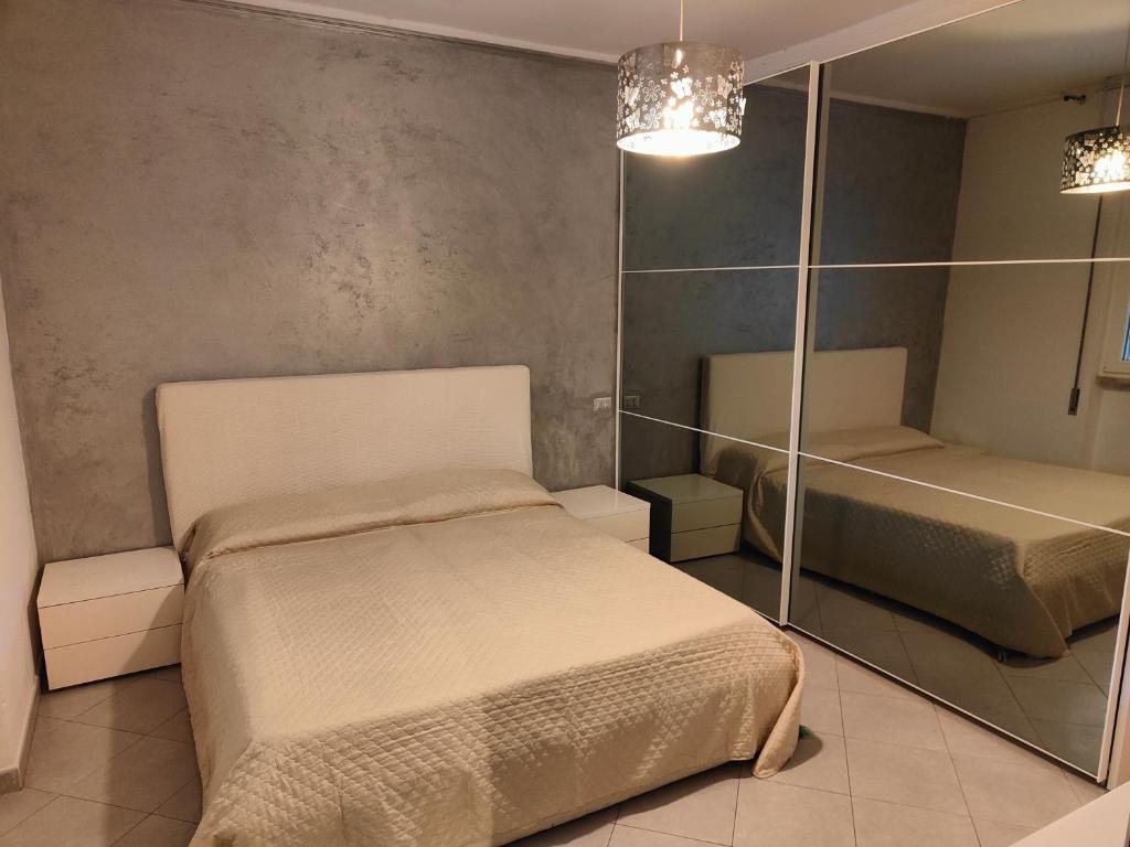 a bedroom with two beds and a mirror at L'appoggio perfetto in Viareggio