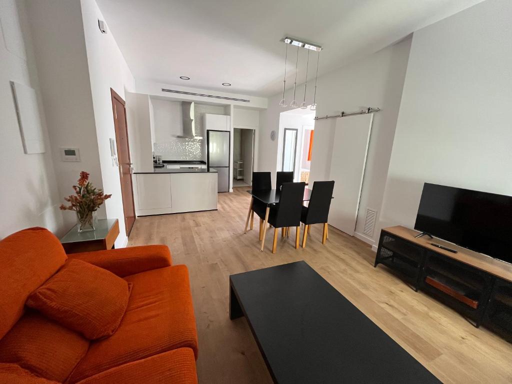 a living room with an orange couch and a table at Loreto N1 in Denia