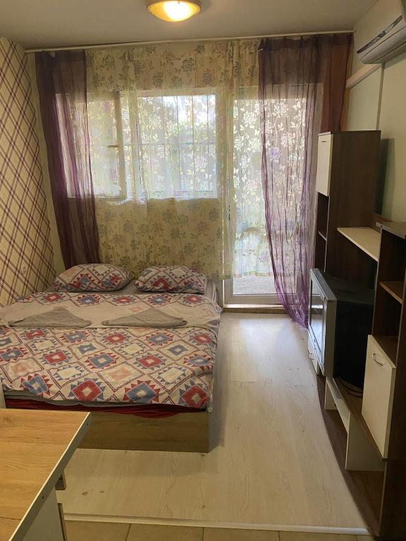 a small bedroom with two beds and a window at Apartment Radetski in Varna City