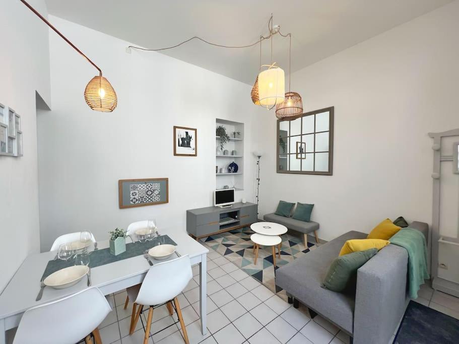 un salon avec un canapé, une table et des chaises dans l'établissement Cour Passy - Centre ville, à La Rochelle