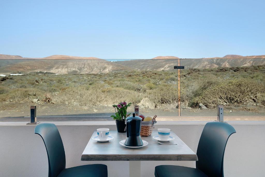 een tafel en stoelen met uitzicht op de woestijn bij Callao Beach 5 in Arrieta