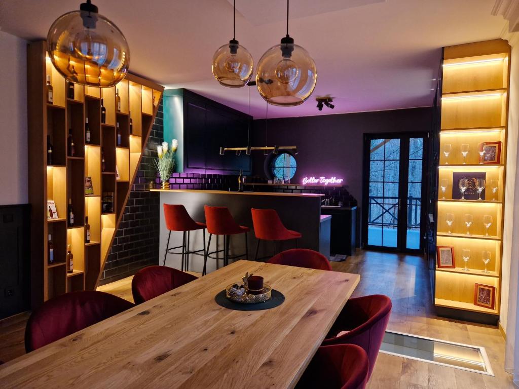 uma sala de jantar com uma mesa de madeira e cadeiras vermelhas em Edit Villa Friends em Matrafured