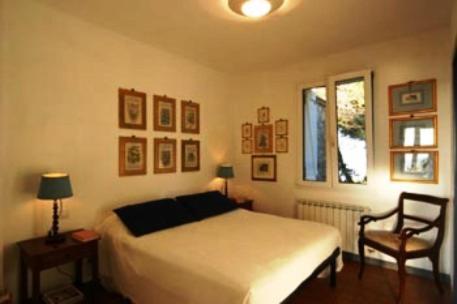 a bedroom with a bed and a chair and a window at La Casa Del Pescatore B&B in Portovenere