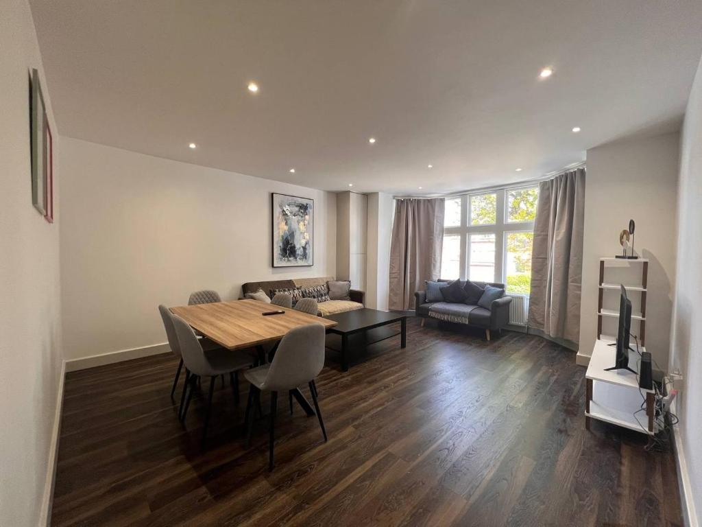 a living room with a dining table and a couch at Star London Finchley Road 2-Bed Residence in London