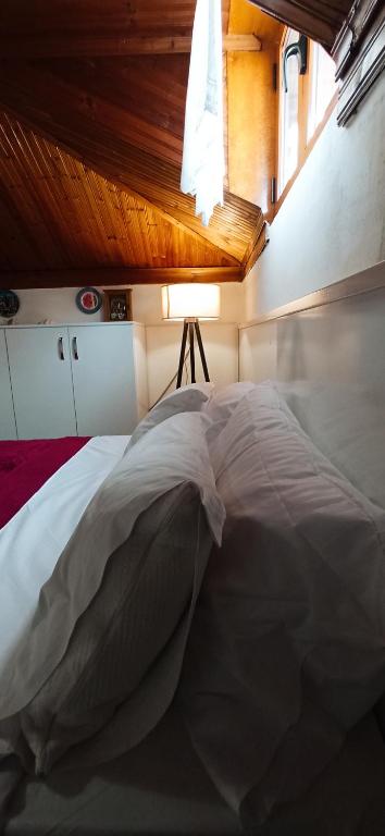 una camera da letto con un letto bianco con una finestra di Tirana Central GuestHouse a Tirana