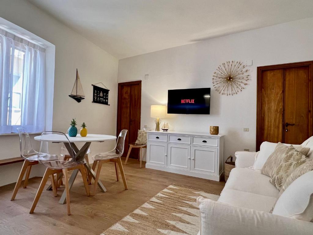 een woonkamer met een witte bank en een tafel bij NUOVO Luminoso a 100 passi dalla piazza in Rio nell Elba