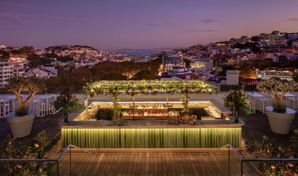 a rooftop garden with a pergola at night at Tivoli Avenida Liberdade Lisboa – A Leading Hotel of the World in Lisbon