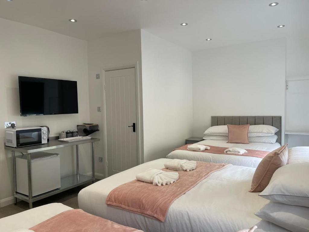 Habitación con 2 camas, TV y escritorio. en Araan House Hotel -Families and Couples Only en Blackpool