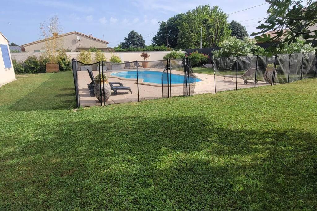 une clôture dans une cour avec une piscine dans l'établissement la villa cocon, à Velleron