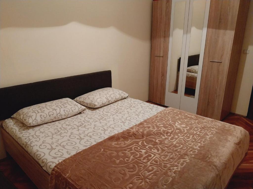 a bedroom with a bed with two pillows on it at Stan na dan - Inđija in Inđija
