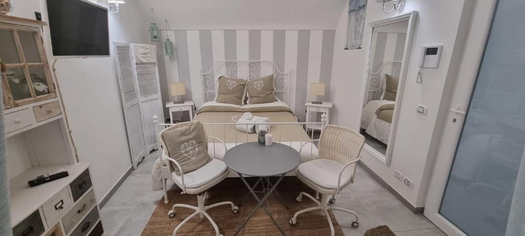 伊斯基亞的住宿－La Cameretta al Porto，小房间设有一张床、一张桌子和椅子