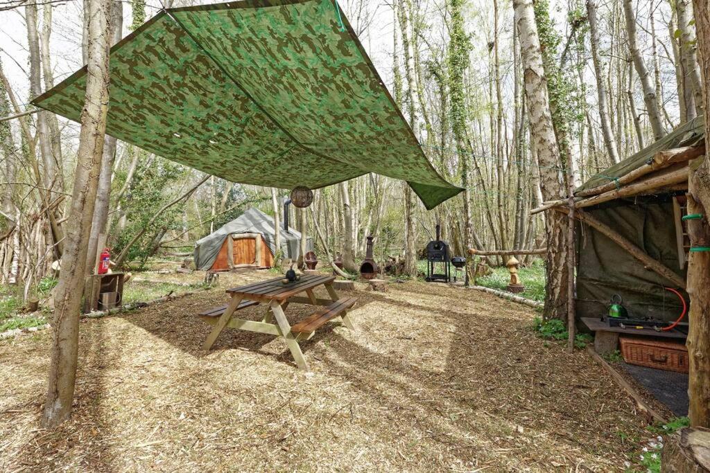 een picknicktafel en een tent in het bos bij Hobbity Bell Hobbity log burner - Hobbity stay in Canterbury