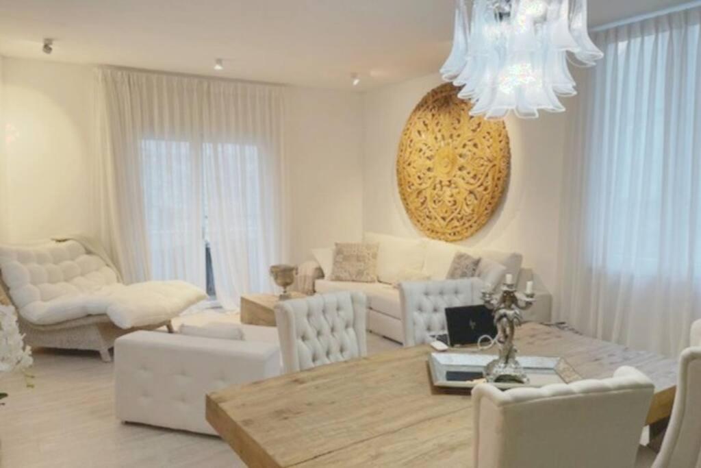 2 Bedroom Apartment in Rovinj في روفينج: غرفة معيشة مع طاولة وأثاث أبيض