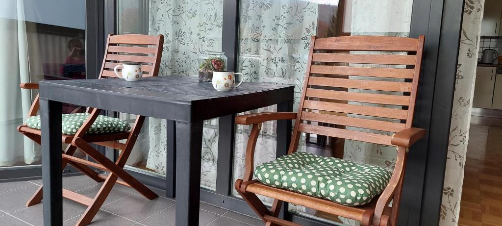 a black table and two chairs on a porch at Apartma Rožmarin Bohinj in Bohinj