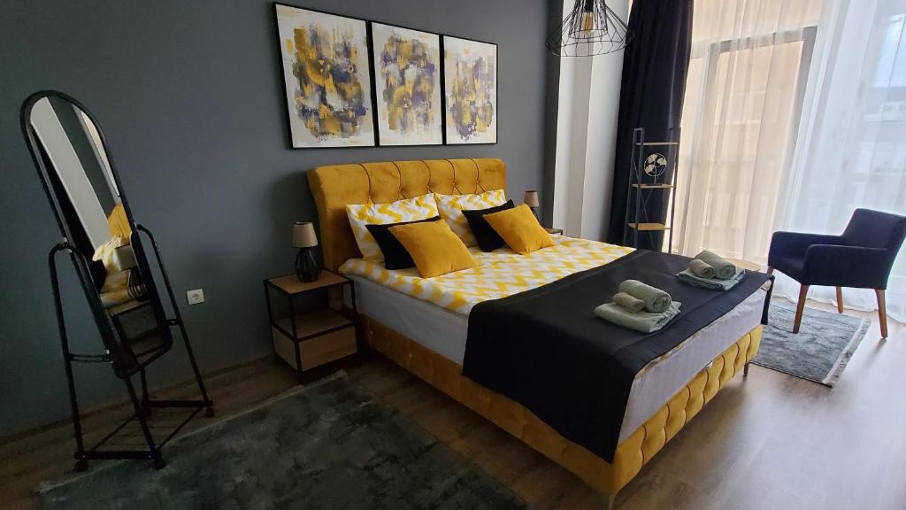 a bedroom with a bed with yellow pillows and a mirror at Apartman Gold in Bugojno