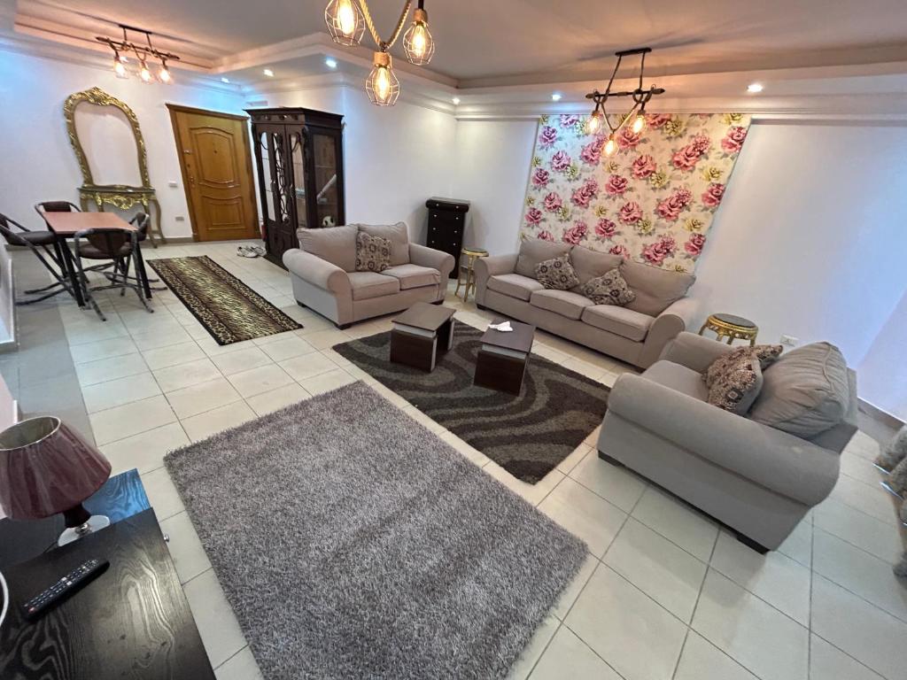 uma grande sala de estar com sofás e uma mesa em شقة فندقية no Cairo