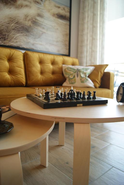 a living room with a chess board on a table at Apartament Garden AiR in Sztutowo