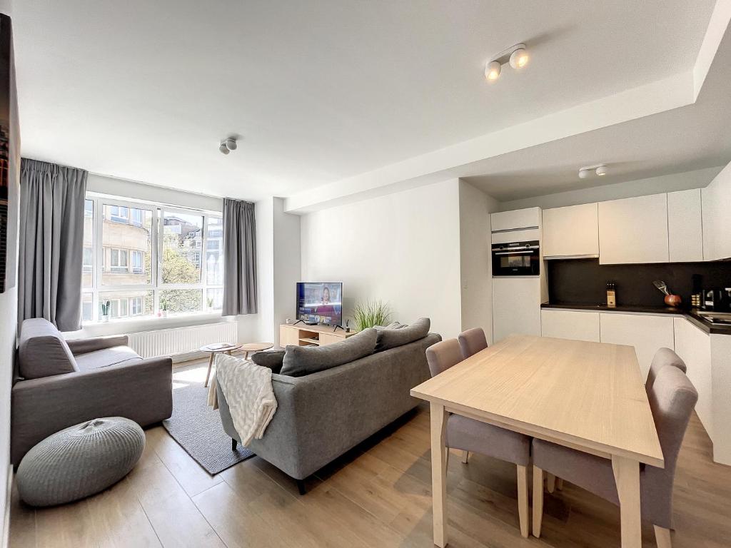 Cosy Apartment Brussels - Avenue Louise في بروكسل: غرفة معيشة مع أريكة وطاولة