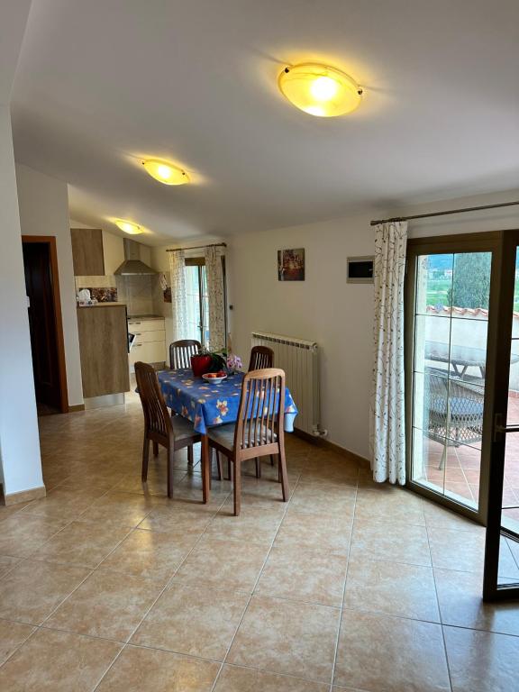 a dining room with a table and chairs and a kitchen at Apartments Primani in Sečovlje