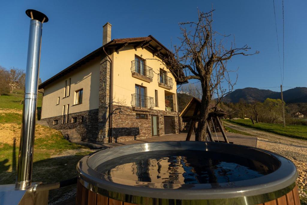 a building with a barrel in front of a house at Montissimo Chalet in Bran