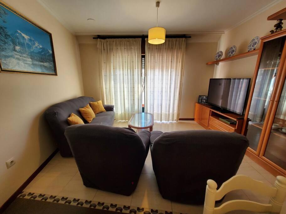 een woonkamer met een bank en een televisie bij Magnifico apartamento en O Grove in O Grove