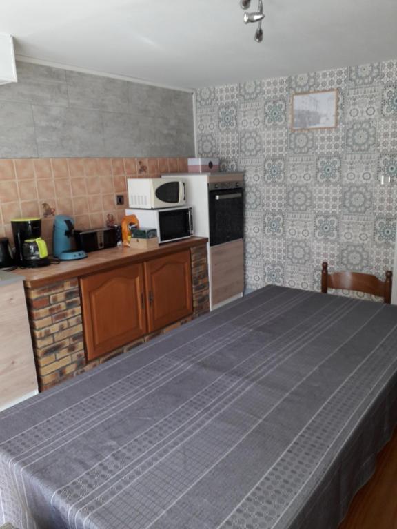 eine Küche mit einem großen Bett in einem Zimmer in der Unterkunft GITE ANNA in Le Châtelet-sur-Sormonne