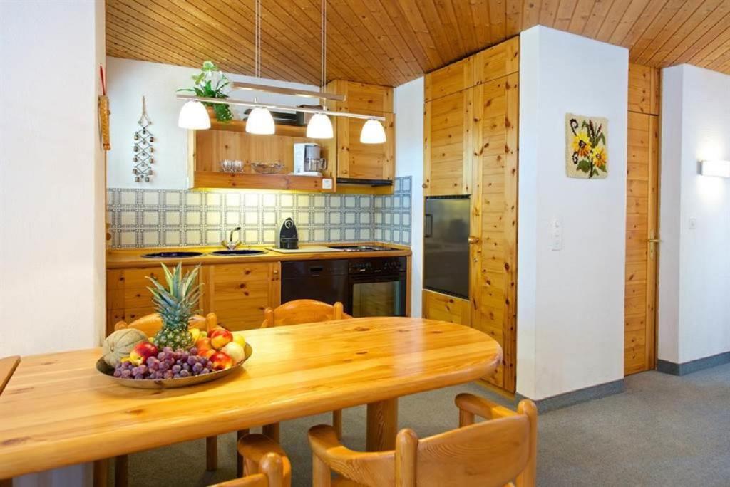 uma cozinha com uma mesa de madeira com uma taça de fruta em Apartment Schweizerhof 242 Lenzerheide em Lenzerheide