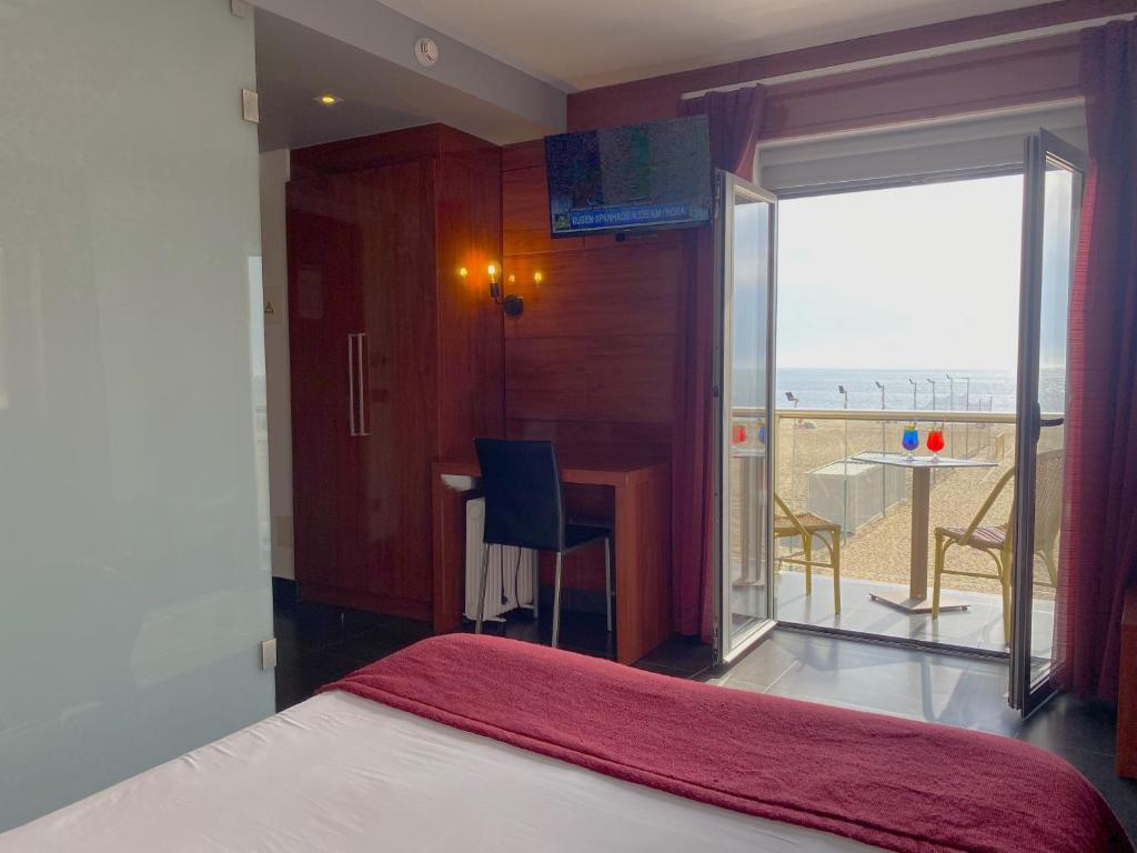 a bedroom with a bed and a view of the ocean at Hotel Oceano in Nazaré