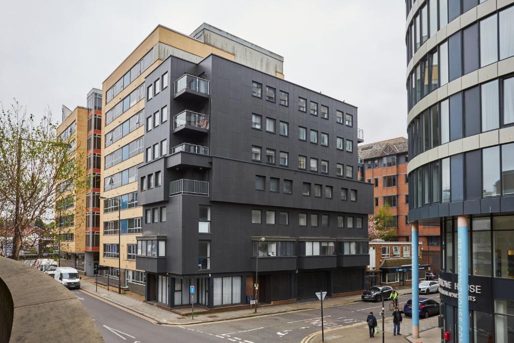 a black building on a city street with buildings at Kings Oak House by Viridian Apartments in London