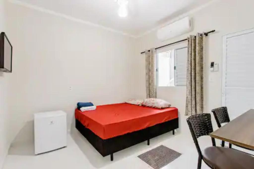 1 dormitorio con 1 cama, mesa y sillas en Pousada Casa da Fernanda, Suíte Moon en Praia Grande