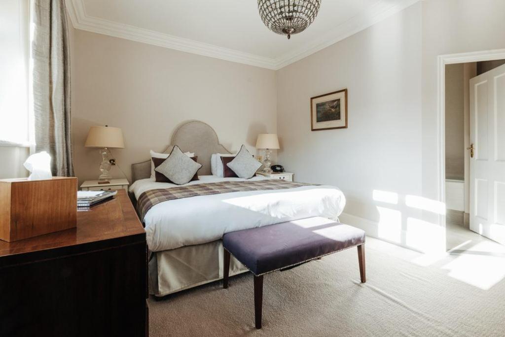 a bedroom with a bed with a desk and a chair at Victoria in Holkham