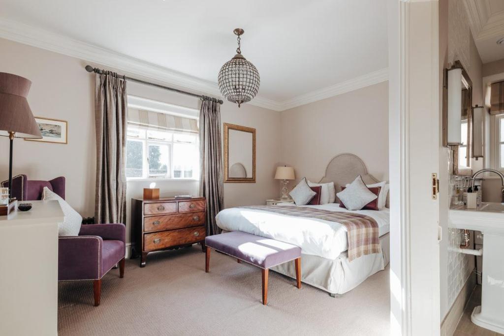 a bedroom with a bed and a purple chair at Victoria in Holkham