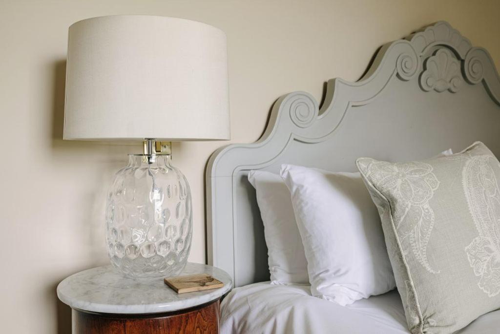 a lamp sitting on a table next to a bed at Victoria in Holkham