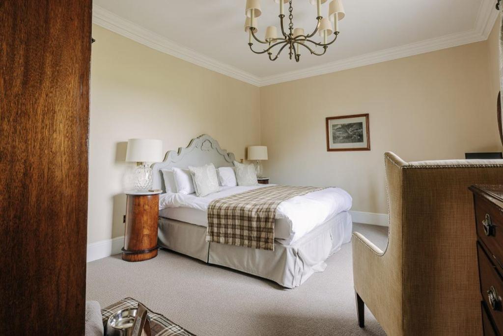 a bedroom with a bed and a chandelier at Victoria in Holkham
