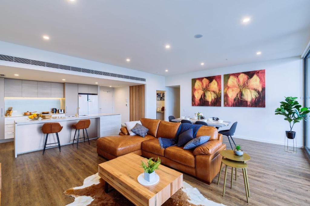 una sala de estar con un sofá y una mesa en Multi Million River View 3BD Penthouse at SouthBank, en Brisbane