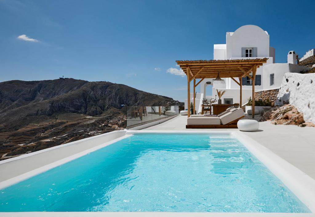 a swimming pool with a view of a mountain at Bluewhite Villa Santorini in Pirgos