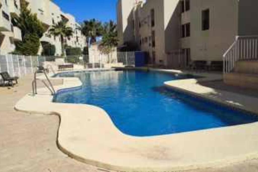 duży niebieski basen w budynku w obiekcie TurAlmeria - Mirador Del Cabo1 - Apartamento con 2 dormitorios, 2 baños, piscina y plaza de garaje con vistas al mar en Retamar - Almería w mieście Retamar
