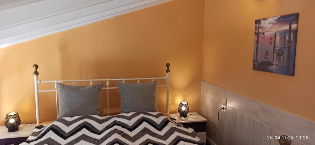 ein Schlafzimmer mit einem Bett und einer gelben Wand in der Unterkunft Marions Haus in Gournes